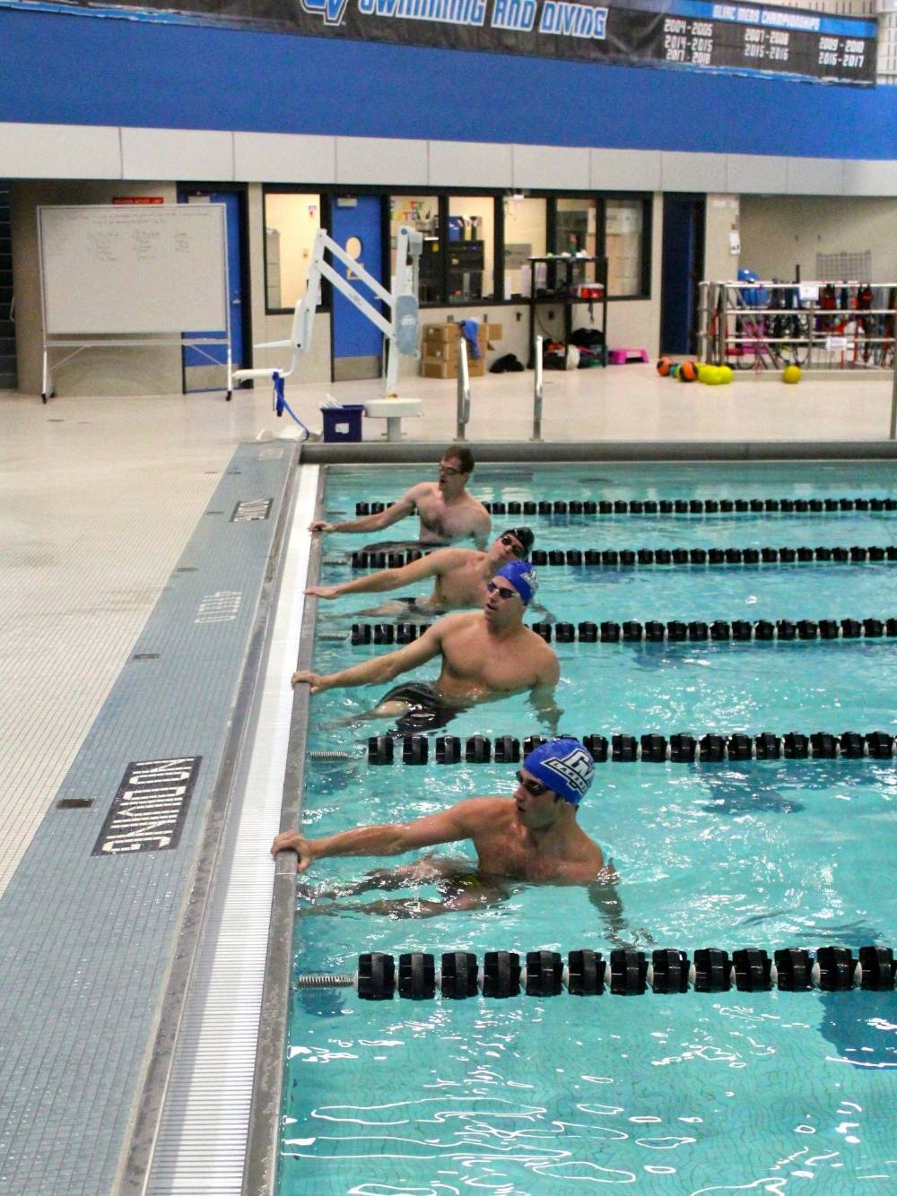 Swimmers in the pool about to take off